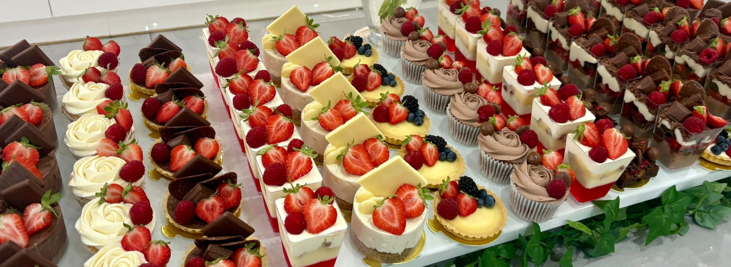 Assorted desserts with strawberries on a white surface